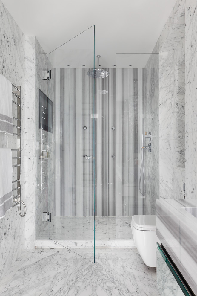 ロンドンにある高級な中くらいなコンテンポラリースタイルのおしゃれなマスターバスルーム (壁掛け式トイレ、白いタイル、グレーのタイル、大理石の床、大理石の洗面台、アルコーブ型シャワー、開き戸のシャワー) の写真