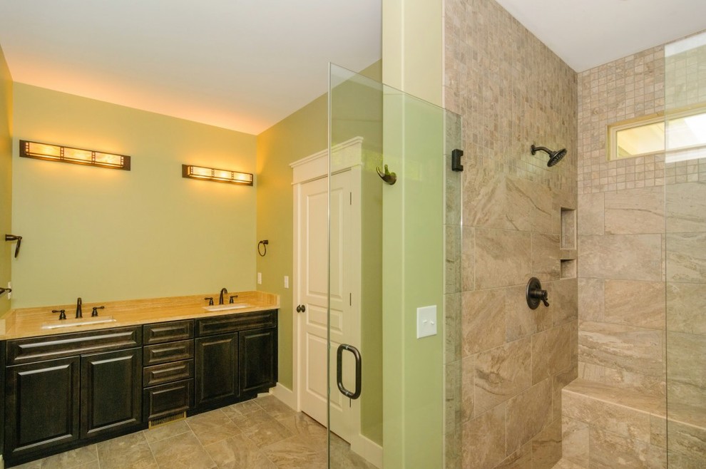 Ispirazione per una stanza da bagno stile rurale con lavabo sottopiano, ante con riquadro incassato, ante nere, doccia a filo pavimento, piastrelle beige, piastrelle di cemento e pareti verdi