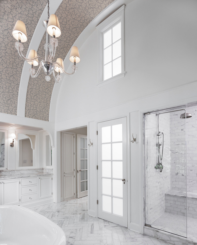 На фото: большая главная ванная комната в современном стиле с плоскими фасадами, белыми фасадами, мраморной столешницей, отдельно стоящей ванной, двойным душем, белой плиткой, белыми стенами и мраморным полом
