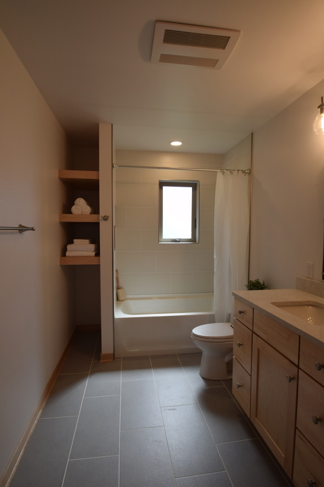 Inspiration for a medium sized traditional bathroom in Other with shaker cabinets, light wood cabinets, an alcove bath, a shower/bath combination, a one-piece toilet, beige tiles, ceramic tiles, beige walls, ceramic flooring, a submerged sink, engineered stone worktops, grey floors, a shower curtain, beige worktops and a single sink.