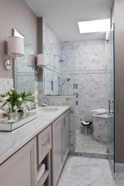 Bild på ett mellanstort vintage en-suite badrum, med ett undermonterad handfat, luckor med infälld panel, vita skåp, marmorbänkskiva, ett undermonterat badkar, en dusch i en alkov, en toalettstol med separat cisternkåpa, vit kakel, stenkakel, grå väggar och marmorgolv