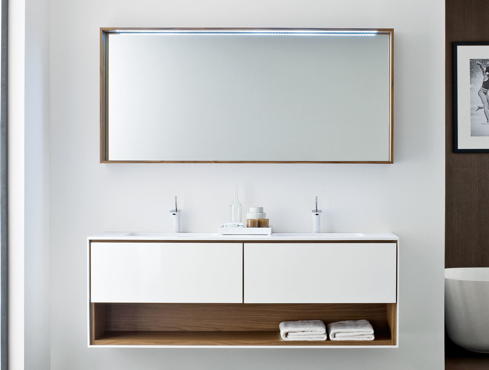 Esempio di una stanza da bagno design con lavabo integrato, ante lisce, ante bianche e pareti bianche