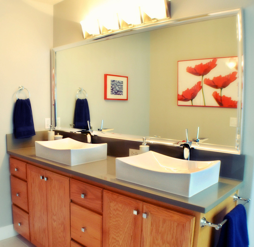 Diseño de cuarto de baño principal asiático de tamaño medio con lavabo sobreencimera, paredes grises, armarios con paneles empotrados, puertas de armario de madera oscura y encimera de laminado