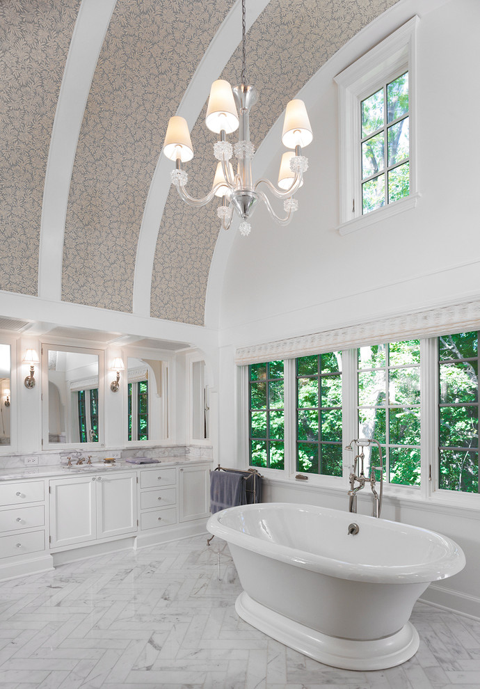 Diseño de cuarto de baño principal actual grande con armarios con paneles lisos, puertas de armario blancas, bañera exenta, baldosas y/o azulejos blancos y paredes blancas