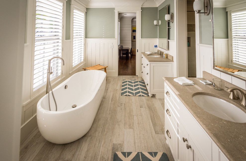 Источник вдохновения для домашнего уюта: большая ванная комната в морском стиле с фасадами в стиле шейкер, белыми фасадами, отдельно стоящей ванной, душем в нише, раздельным унитазом, зелеными стенами, полом из керамогранита, душевой кабиной, врезной раковиной, столешницей из известняка, бежевым полом и душем с раздвижными дверями