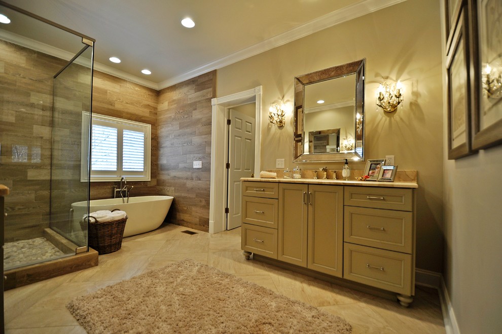 Modelo de cuarto de baño clásico con lavabo bajoencimera, armarios con paneles empotrados, encimera de mármol y bañera exenta