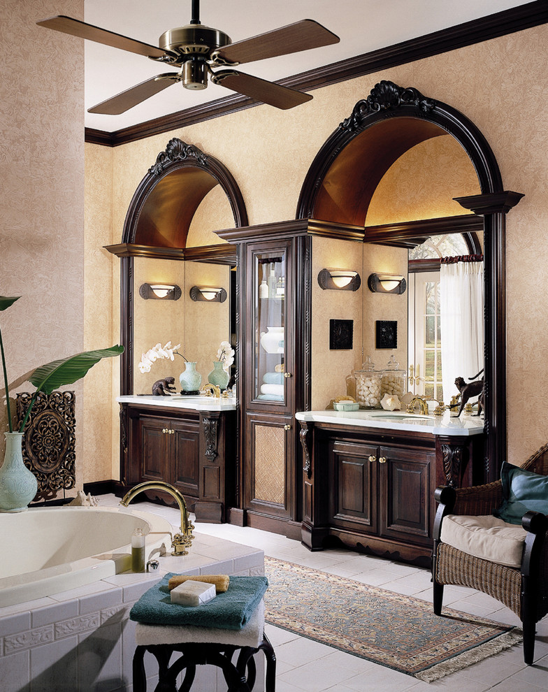 Ejemplo de cuarto de baño principal tradicional extra grande con armarios con paneles con relieve, puertas de armario de madera en tonos medios, bañera encastrada y paredes beige