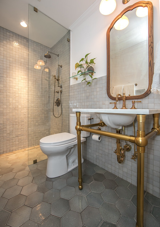Exempel på ett mellanstort klassiskt vit vitt badrum med dusch, med vita skåp, en kantlös dusch, en toalettstol med separat cisternkåpa, grå kakel, perrakottakakel, grå väggar, klinkergolv i keramik, ett undermonterad handfat, marmorbänkskiva, grått golv och med dusch som är öppen