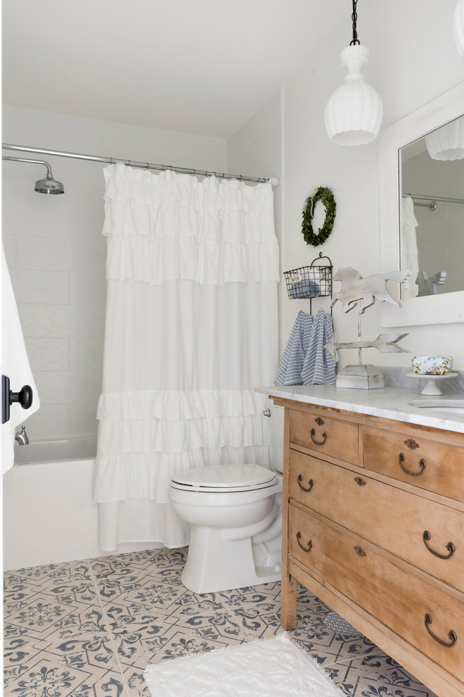 Foto på ett lantligt vit badrum för barn, med vita väggar, skåp i mellenmörkt trä, ett badkar i en alkov, en dusch/badkar-kombination, vit kakel, ett undermonterad handfat, flerfärgat golv och dusch med duschdraperi
