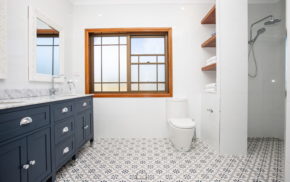 Idéer för mellanstora funkis en-suite badrum, med blå skåp, en dubbeldusch, en toalettstol med hel cisternkåpa, vit kakel, keramikplattor, vita väggar, klinkergolv i keramik, ett integrerad handfat, granitbänkskiva, blått golv och med dusch som är öppen