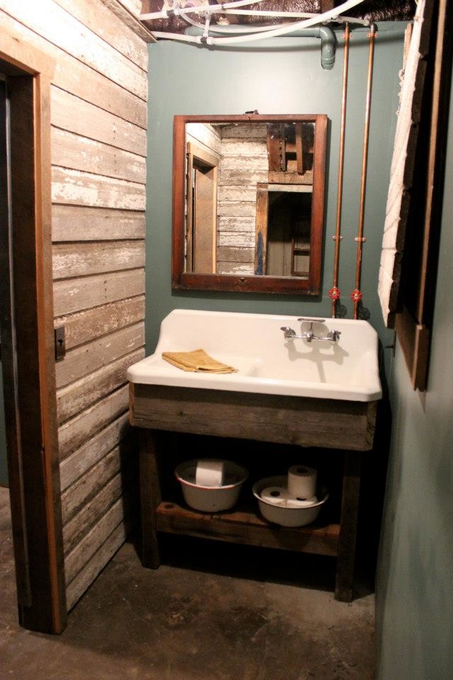 Immagine di una stanza da bagno chic di medie dimensioni con lavabo integrato, nessun'anta, ante con finitura invecchiata, pareti blu e pavimento in cemento