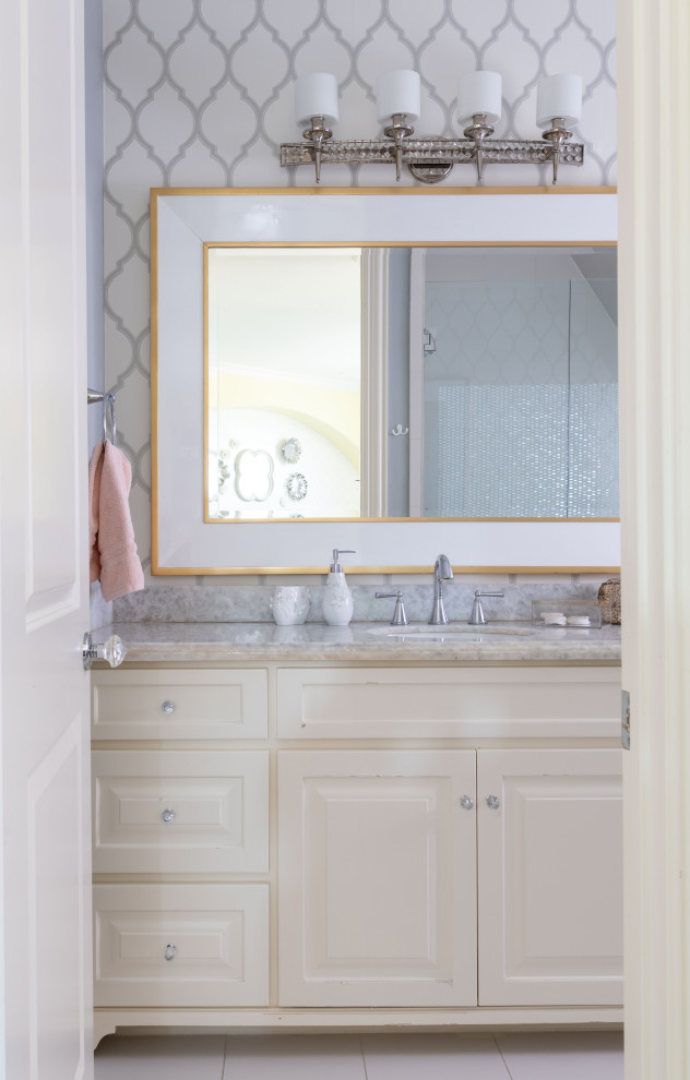 Foto på ett litet vintage grå badrum för barn, med luckor med upphöjd panel, vita skåp, vit kakel, stickkakel, grå väggar, klinkergolv i porslin, ett nedsänkt handfat, granitbänkskiva och vitt golv