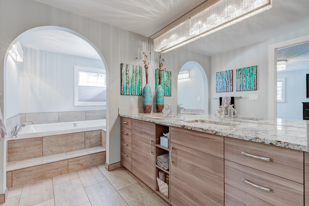 Inspiration for a traditional ensuite bathroom in Calgary with flat-panel cabinets, light wood cabinets, a built-in bath, beige tiles, ceramic tiles, white walls, a submerged sink and granite worktops.