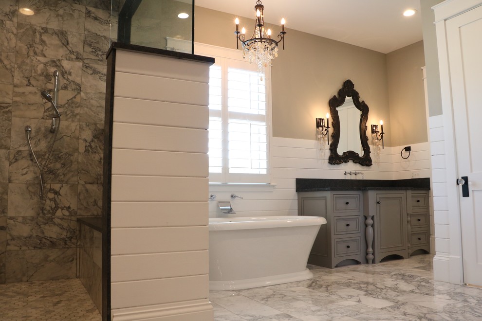 Inspiration for a large farmhouse master white tile marble floor and gray floor bathroom remodel in Other with gray walls, beaded inset cabinets, gray cabinets, a two-piece toilet, an undermount sink, granite countertops, a hinged shower door and black countertops
