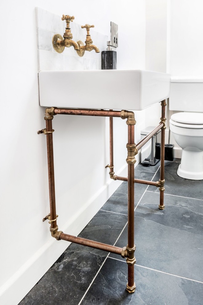 Modern inredning av ett mellanstort badrum med dusch, med en öppen dusch, en toalettstol med separat cisternkåpa, grå kakel, marmorkakel, vita väggar, ett piedestal handfat, svart golv och med dusch som är öppen