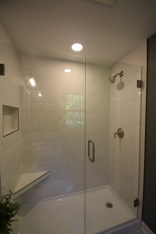 他の地域にある小さなトラディショナルスタイルのおしゃれなバスルーム (浴槽なし) (アルコーブ型シャワー、一体型トイレ	、白いタイル、サブウェイタイル、緑の壁、セラミックタイルの床、ペデスタルシンク、白い床、開き戸のシャワー、シャワーベンチ、洗面台1つ、羽目板の壁) の写真