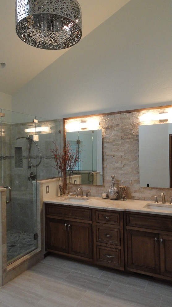 Idées déco pour une grande salle de bain principale contemporaine en bois brun avec un lavabo encastré, une douche d'angle, un carrelage beige, un carrelage de pierre, un mur blanc, un placard avec porte à panneau surélevé et un plan de toilette en marbre.