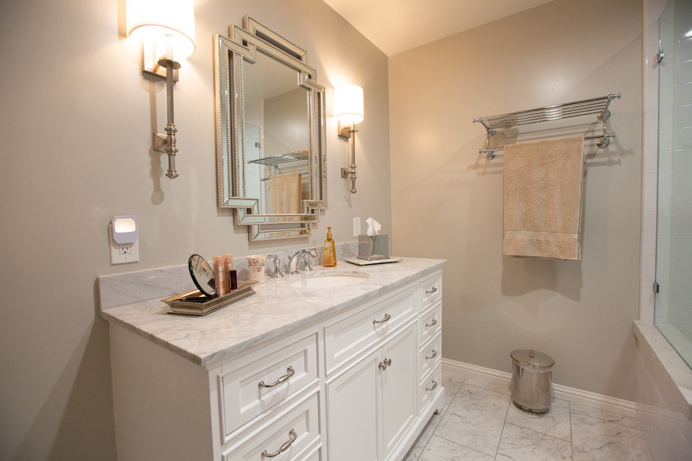 Bild på ett mellanstort vintage vit vitt badrum med dusch, med vita skåp, en hörndusch, vit kakel, klinkergolv i porslin, ett undermonterad handfat, marmorbänkskiva, vitt golv, dusch med gångjärnsdörr, luckor med infälld panel, tunnelbanekakel och grå väggar