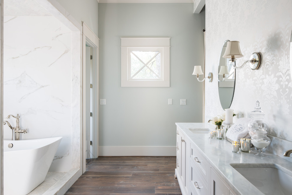 This is an example of a large farmhouse ensuite wet room bathroom in Atlanta with recessed-panel cabinets, grey cabinets, a japanese bath, white tiles, marble tiles, blue walls, medium hardwood flooring, a submerged sink, marble worktops and an open shower.