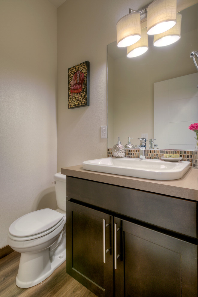 Aménagement d'une petite salle de bain craftsman en bois foncé avec un placard avec porte à panneau encastré, un carrelage beige, des carreaux de céramique, un mur blanc, un sol en carrelage de céramique, un lavabo encastré et un plan de toilette en carrelage.