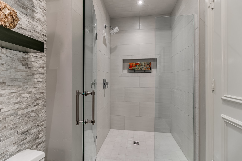 Cette image montre une salle de bain design de taille moyenne avec un placard à porte plane, des portes de placard noires, un carrelage blanc, un mur gris, un sol en carrelage de céramique, une vasque, un plan de toilette en granite, un sol beige et une cabine de douche à porte battante.