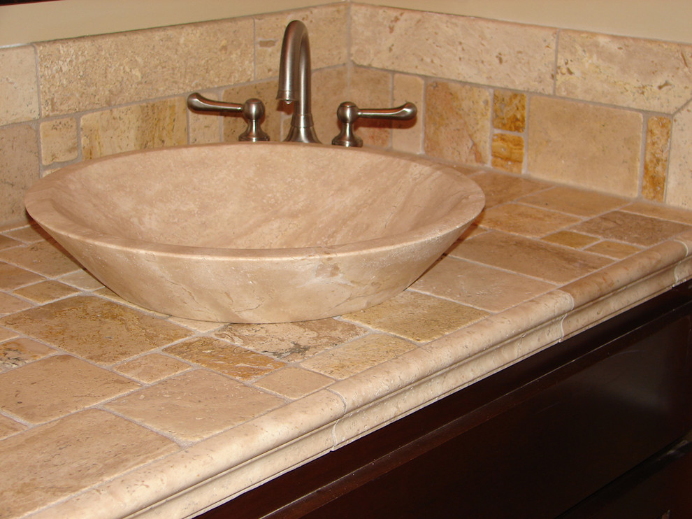 Tuscan beige tile and stone tile bathroom photo in Minneapolis with a vessel sink, flat-panel cabinets, dark wood cabinets and tile countertops