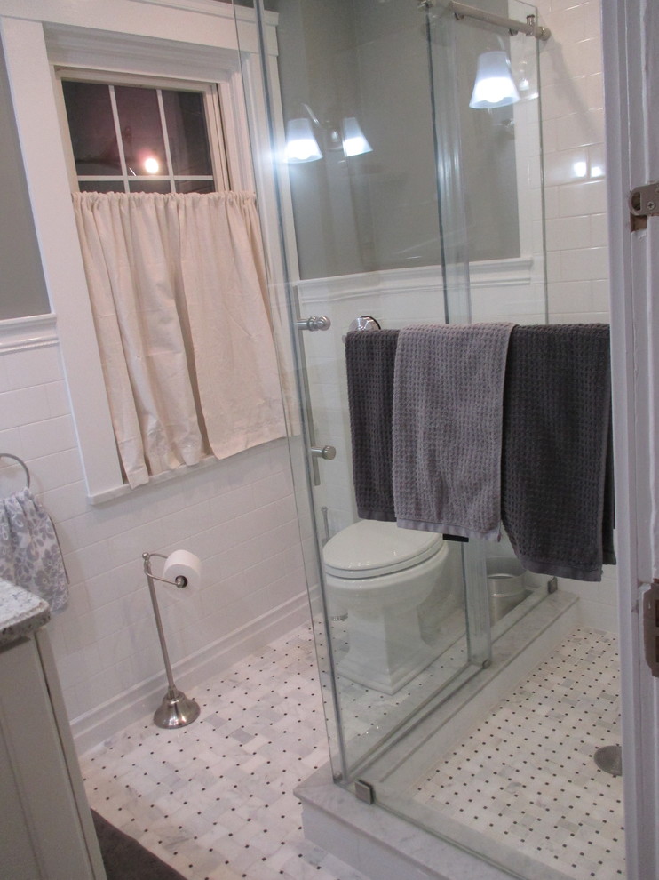 Foto på ett litet vintage grå badrum med dusch, med vita skåp, en hörndusch, en toalettstol med separat cisternkåpa, vit kakel, tunnelbanekakel, grå väggar, marmorgolv, granitbänkskiva, grått golv och dusch med gångjärnsdörr