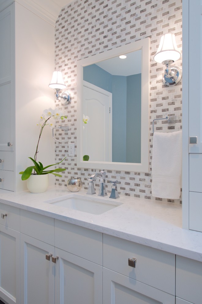 バンクーバーにある高級な広いトランジショナルスタイルのおしゃれなマスターバスルーム (アンダーカウンター洗面器、シェーカースタイル扉のキャビネット、珪岩の洗面台、アルコーブ型浴槽、オープン型シャワー、一体型トイレ	、青い壁、セラミックタイルの床、白いキャビネット、グレーのタイル、白いタイル) の写真
