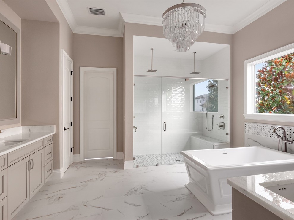 Mid-sized transitional 3/4 ceramic tile porcelain tile and white floor bathroom photo in Orlando with recessed-panel cabinets, gray cabinets, beige walls, an undermount sink, marble countertops, a hinged shower door and white countertops