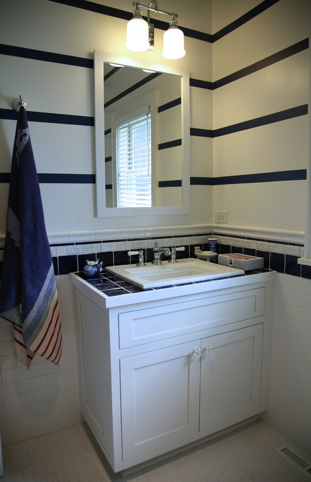 На фото: ванная комната среднего размера в стиле неоклассика (современная классика) с фасадами с утопленной филенкой, белыми фасадами, угловым душем, раздельным унитазом, синей плиткой, керамической плиткой, белыми стенами, полом из мозаичной плитки, душевой кабиной, накладной раковиной и столешницей из плитки