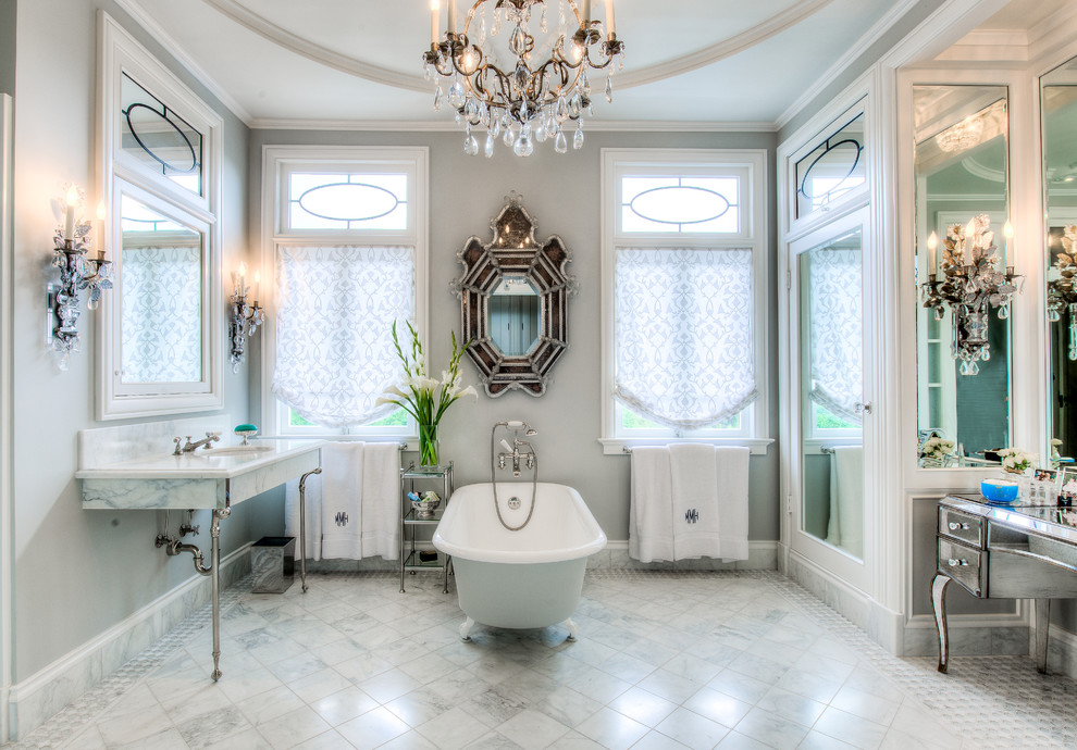На фото: ванная комната в классическом стиле с ванной на ножках и консольной раковиной