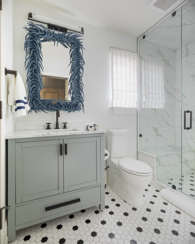 Пример оригинального дизайна: ванная комната среднего размера в стиле неоклассика (современная классика) с серыми фасадами, душем в нише, унитазом-моноблоком, белыми стенами, душевой кабиной, врезной раковиной, разноцветным полом, душем с распашными дверями, белой плиткой, полом из мозаичной плитки, белой столешницей и фасадами в стиле шейкер