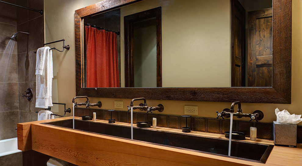 Inredning av ett klassiskt stort badrum med dusch, med ett nedsänkt handfat, släta luckor, skåp i ljust trä, träbänkskiva, ett platsbyggt badkar, en dusch/badkar-kombination, brun kakel, kakel i metall och beige väggar
