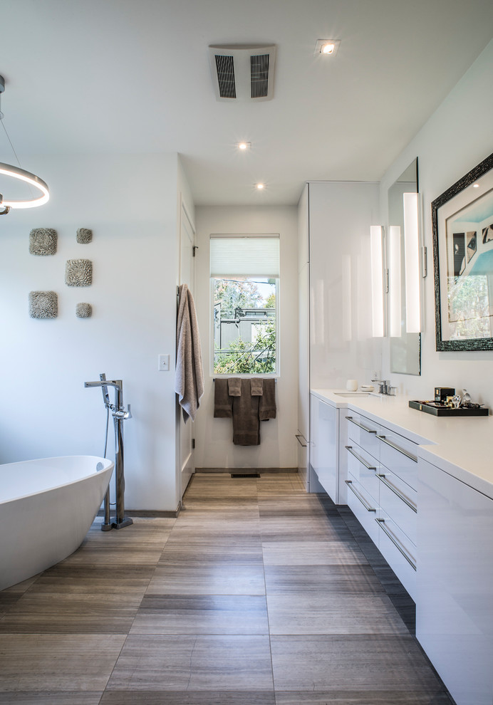 Источник вдохновения для домашнего уюта: ванная комната в современном стиле с плоскими фасадами, белыми фасадами, отдельно стоящей ванной, белыми стенами, душевой кабиной, врезной раковиной, коричневым полом и белой столешницей