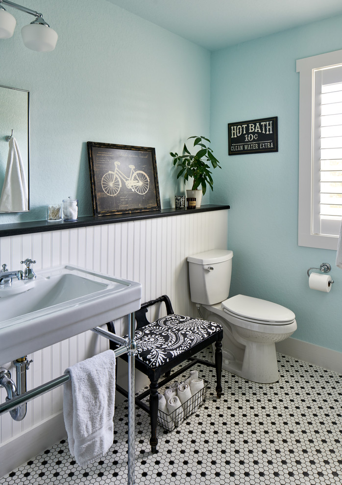 Imagen de cuarto de baño azulejo de dos tonos campestre con sanitario de dos piezas, paredes azules, lavabo tipo consola y suelo multicolor