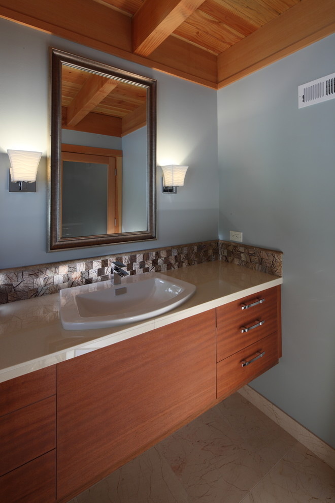 Idéer för ett litet modernt badrum, med ett nedsänkt handfat, släta luckor, skåp i mellenmörkt trä, kaklad bänkskiva, en toalettstol med separat cisternkåpa, beige kakel, stenkakel, blå väggar och marmorgolv