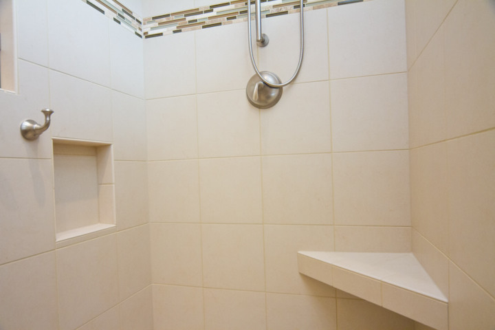 Immagine di una grande stanza da bagno moderna con ante a filo, doccia doppia, WC a due pezzi, pavimento in gres porcellanato, lavabo sottopiano e top in granito