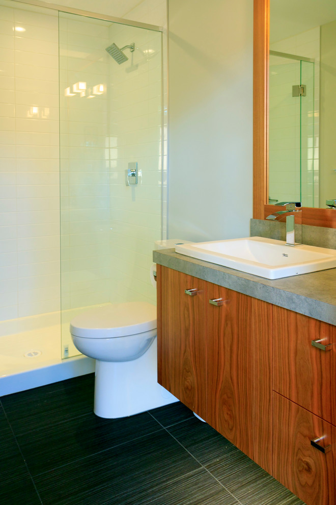 Стильный дизайн: ванная комната среднего размера в современном стиле с плоскими фасадами, фасадами цвета дерева среднего тона, душем в нише, серыми стенами, полом из керамогранита, душевой кабиной, накладной раковиной и столешницей из ламината - последний тренд