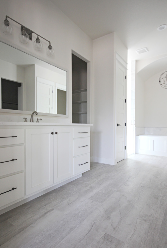 Foto de cuarto de baño principal de estilo de casa de campo extra grande con armarios estilo shaker, puertas de armario blancas y encimeras blancas