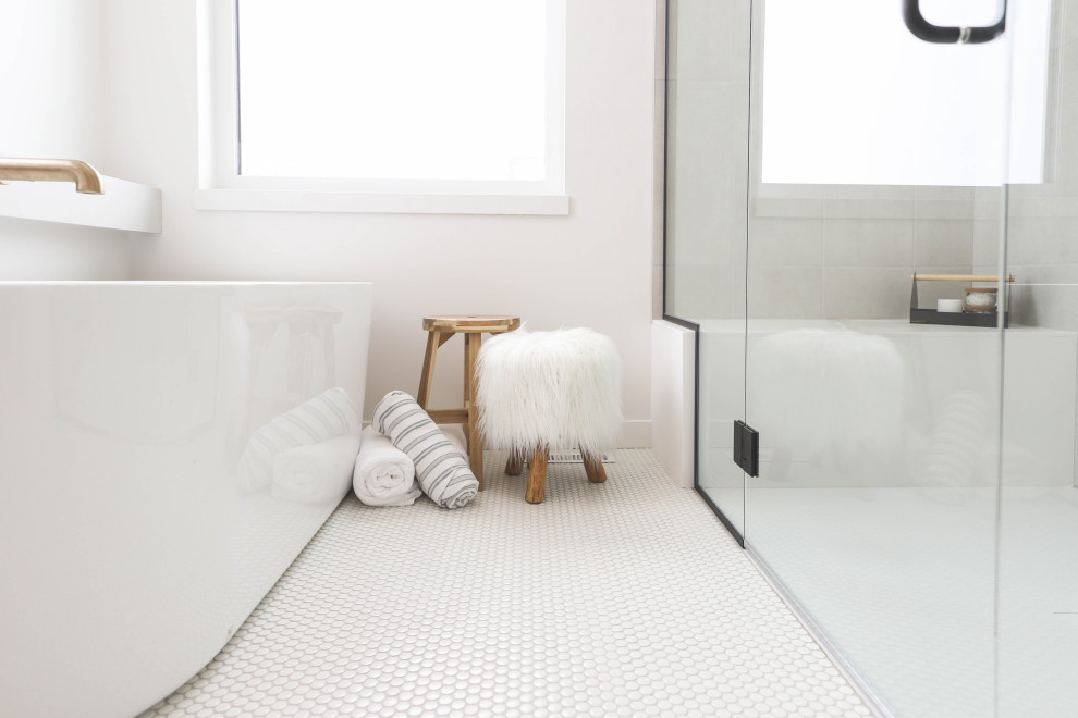 Nordisk inredning av ett en-suite badrum, med släta luckor, skåp i ljust trä, ett fristående badkar, en dusch i en alkov, grå kakel, keramikplattor, klinkergolv i keramik, ett fristående handfat, bänkskiva i kvartsit, vitt golv och dusch med gångjärnsdörr