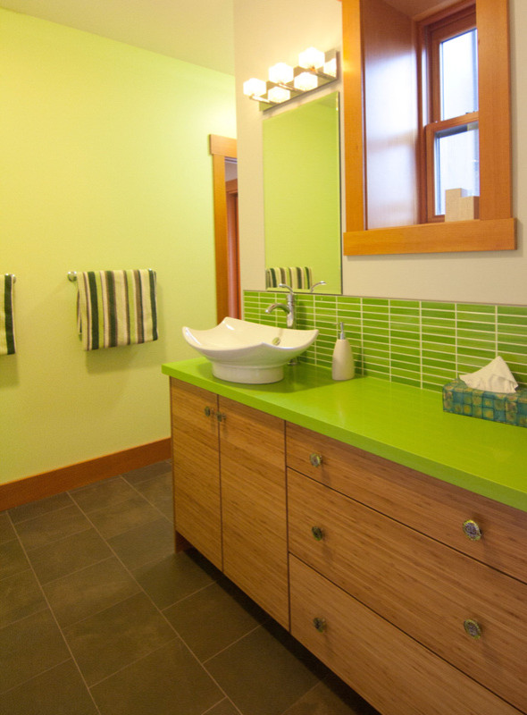Mittelgroßes Modernes Badezimmer En Suite mit flächenbündigen Schrankfronten, hellbraunen Holzschränken, grünen Fliesen, Fliesen aus Glasscheiben, grüner Wandfarbe, Porzellan-Bodenfliesen, Aufsatzwaschbecken, Mineralwerkstoff-Waschtisch und braunem Boden in Toronto