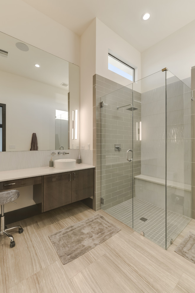 This is an example of a medium sized modern ensuite bathroom in Austin with glass-front cabinets, medium wood cabinets, a freestanding bath, a walk-in shower, a one-piece toilet, brown tiles, marble tiles, white walls, porcelain flooring, a vessel sink, marble worktops, brown floors, an open shower and multi-coloured worktops.