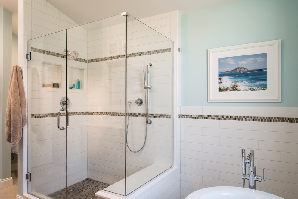 Cette image montre une salle de bain principale marine avec une baignoire indépendante, une douche d'angle, un carrelage blanc et un mur bleu.