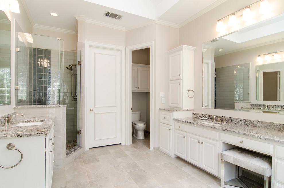 Medium sized traditional ensuite bathroom in Dallas with a submerged sink, raised-panel cabinets, white cabinets, granite worktops, a freestanding bath, a corner shower, a two-piece toilet, grey tiles, porcelain tiles, grey walls and porcelain flooring.