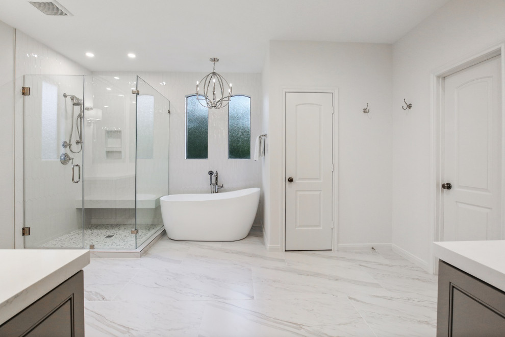 Exemple d'une salle de bain principale chic de taille moyenne avec un placard avec porte à panneau surélevé, des portes de placard grises, une baignoire indépendante, une douche d'angle, WC séparés, un carrelage blanc, des carreaux de céramique, un mur blanc, un sol en carrelage de céramique, un lavabo encastré, un plan de toilette en quartz modifié, un sol blanc, une cabine de douche à porte battante, un plan de toilette blanc, un banc de douche, meuble double vasque et meuble-lavabo encastré.