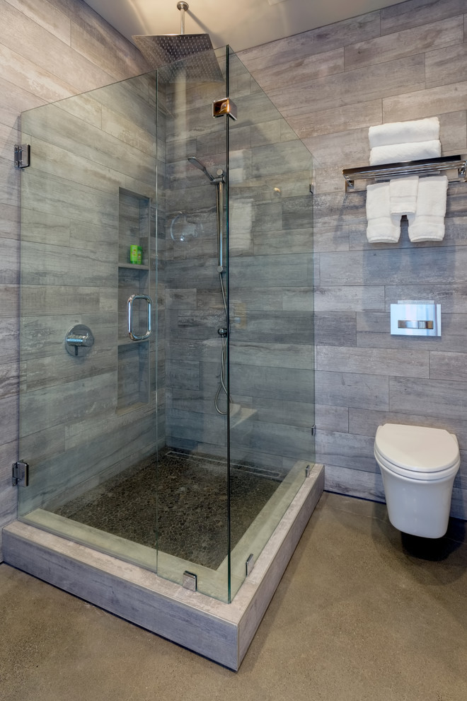 Réalisation d'une salle d'eau urbaine de taille moyenne avec une douche d'angle, WC à poser, un carrelage gris, des carreaux de céramique, un mur gris, sol en béton ciré, un lavabo de ferme, un sol beige et une cabine de douche à porte battante.