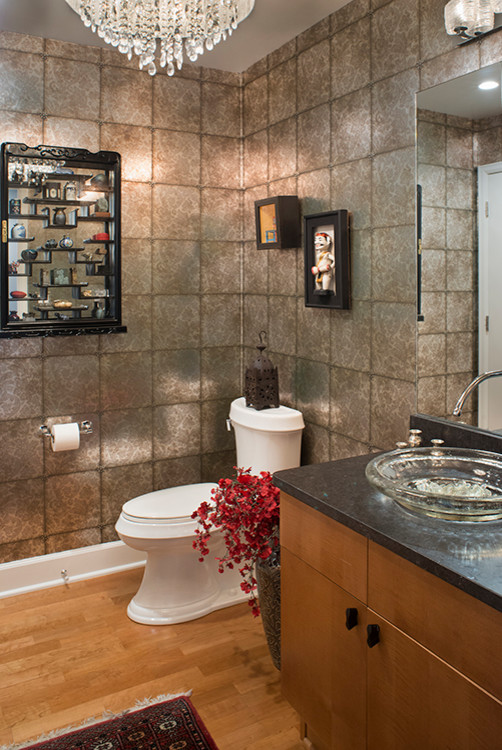 Photo of a medium sized classic bathroom in Denver with flat-panel cabinets, medium wood cabinets, a two-piece toilet, grey walls, medium hardwood flooring, a vessel sink, soapstone worktops, brown floors and black worktops.