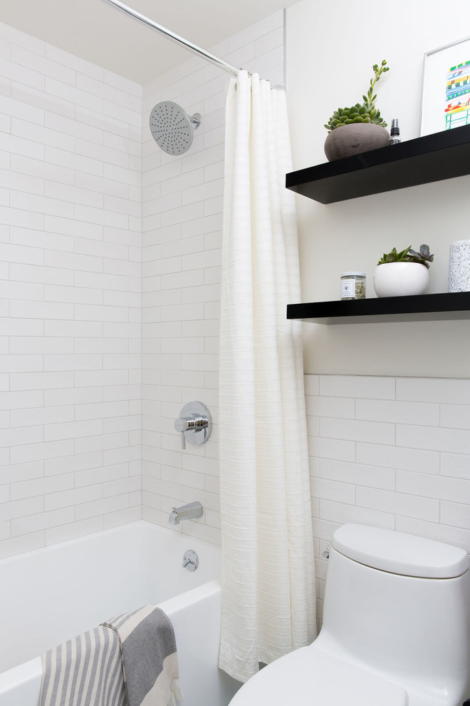 Modern inredning av ett litet vit vitt badrum för barn, med släta luckor, skåp i ljust trä, ett platsbyggt badkar, en dusch/badkar-kombination, vit kakel, keramikplattor, klinkergolv i porslin, bänkskiva i akrylsten, blått golv och dusch med duschdraperi