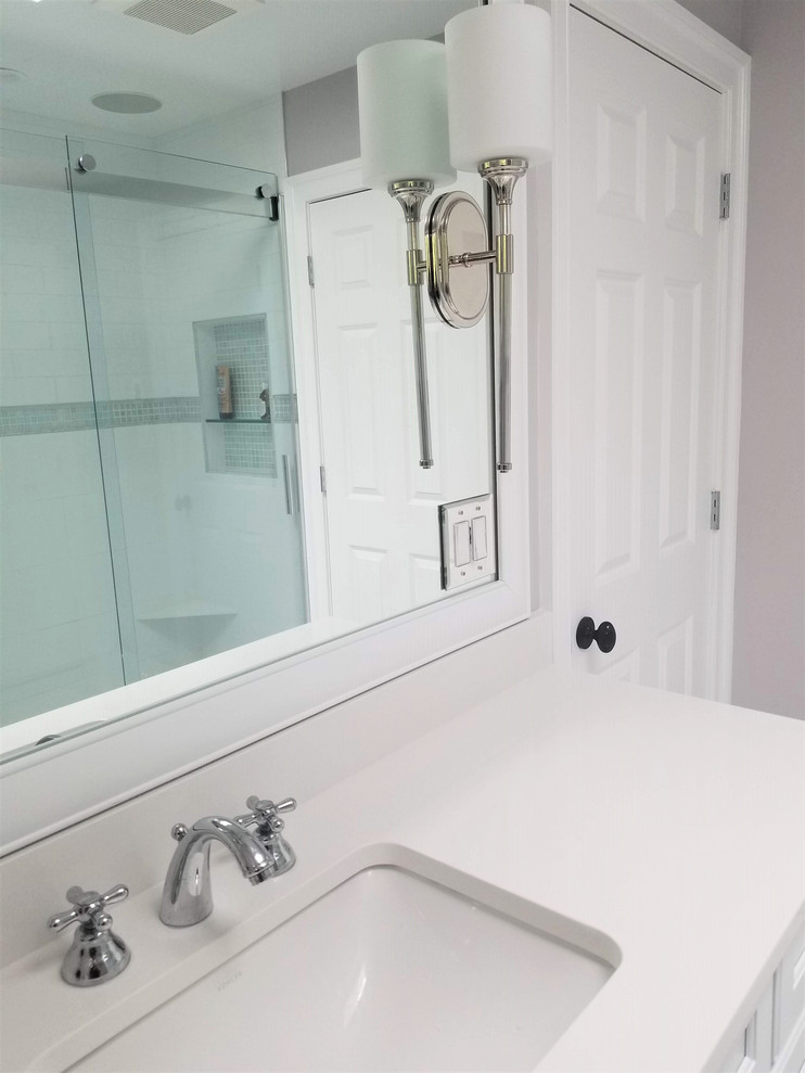 Photo of a medium sized traditional family bathroom in New York with shaker cabinets, white cabinets, an alcove shower, a one-piece toilet, white tiles, porcelain tiles, purple walls, porcelain flooring, a submerged sink, engineered stone worktops, white floors, a sliding door and white worktops.