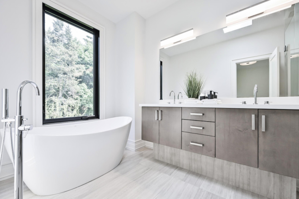 Mid-sized transitional master gray tile and porcelain tile porcelain tile, gray floor and double-sink bathroom photo in Toronto with marble countertops, flat-panel cabinets, brown cabinets, white walls, an undermount sink, white countertops, a built-in vanity, a one-piece toilet and a hinged shower door